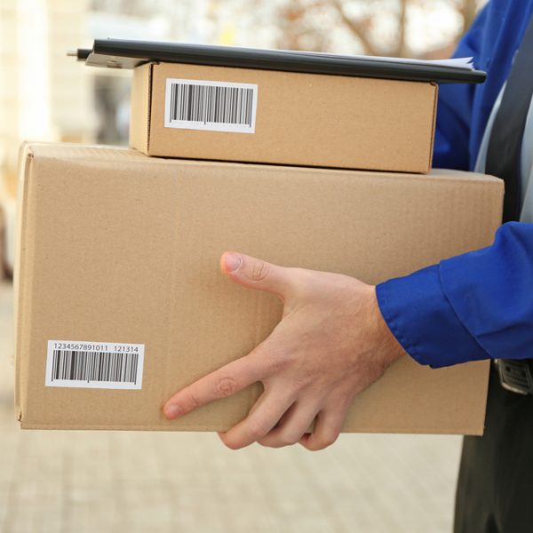 Courier with parcels on doorstep, closeup